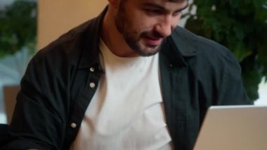 Kafkasyalı adamı kapatın laptopta çalışırken ellerinizi gevşetin. İşyerinizin arkasında gevşetin. Çevrimiçi serbest çalışan erkek bilgisayar işadamı, masaüstü adamı kulaklıklar.