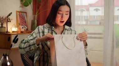 Mutlu Asyalı Koreli Çinli kadın paket satın alıyor. Parlayan kadın şaşkınlığı duyguları. Eve gülümseyen iş kadını.