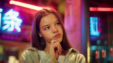 Düşünceli, kafası karışmış Asyalı, beyaz çocuk. Düşünceli kız, kızının sorunlarını çözdüğünü düşünüyor. Neon, genç kız öğrencinin şehirde beyin fırtınası.