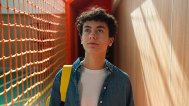 Spor sınıfına giderken sakince yürümek, beyaz erkek, ergen, ergen öğrenci yürüyüşü, üniversite akademisi eğitimi almak için okula gitmek, kapalı alanda tek başına öğrenim görmek.