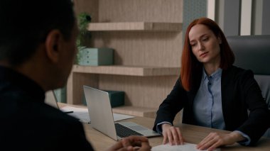 Ofiste buluşan çok ırklı iş adamları mutlu Kafkasyalı iş kadını belgeleri alıyor CV başvuru formlarına devam ediyor aday erkek müşteri işe alıyor iş adamı ortaklığı teklif ediyor