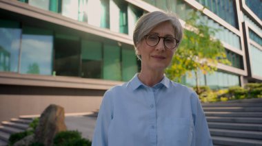 Şehirli, yetişkin, beyaz kadın, orta yaşlı, iş kadını, iş kadını, emlakçı, ofis müdürü, açık havada gülümseyen olgun kadın portresi.