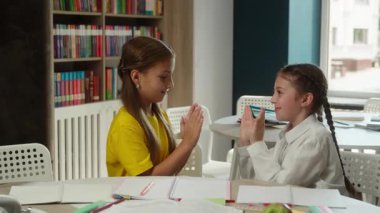 Komik liseli kızlar küçük çocuklar çocuk okulu öğrencileri Kafkasyalı kızlar sınıf arkadaşları mutlu arkadaşlar sınıf eğitiminde birlikte oynayan kız kardeşler oyun zamanı alkışları el çırpma oyun çocukluğu