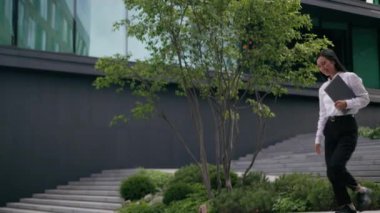 Mutlu Asyalı başarılı Çinli Japon kadın merdivenlerden iniyor çalışan yönetici klasör bayan iş kadını iş kadını iş kadını iş kadını şehir merkezinin dışında çalışan yönetici.
