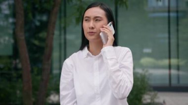 Asyalı Koreli Çinli bir kadın cep telefonuyla konuşuyor. Akıllı cep telefonu cevap vermiyor. Konuşmayı reddediyor.