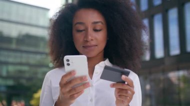 Afrika kökenli Amerikalı bir kadın cep telefonu akıllı telefon kartı kullanıyor çevrimiçi ödemeli internet uygulaması finansmanı kadın işkadını sipariş alışveriş merkezini satın alıyor kız teknolojisi bankası dışında nakit kredi