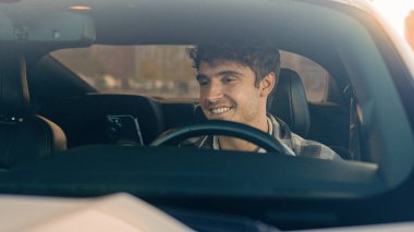 Mutlu gülümseyen iş adamı araba kentsel sürüş yaşam tarzında telefon uygulamaları kullanıyor mobil uygulamalı akıllı telefon otomatik GPS navigasyonunda. Neşeli erkek sürücü, trafik sıkışıklığında bekliyor.