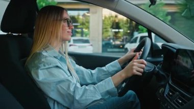 Beyaz kadın iş kadını şehir otomobili kadın sürücü kız taşıma aracı şehir elektro kadın gülen direksiyon kiralama servisi zevkle hareket ediyor