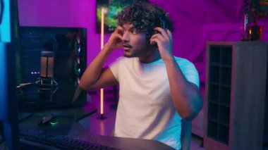 Arap asıllı Latin adam video yayınını kulaklıklara taktı mikrofon çaldı mikrofon çaldı oyun oynadı bilgisayar etkileyicisi erkek kollarını uzattı kablosuz konuşmalar ev kulaklıkları çalmaya başladı