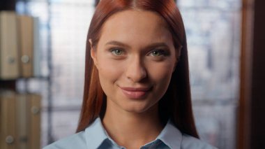 Şirket ofisinde gülümseyen güzel, kendine güvenen bir öğrenci kız iş kadını, kamera işkadını, bayan işveren, şirket çalışanı pazarlama uzmanı kadın fotoğrafa bakıyor.