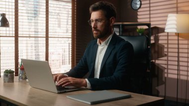 Konsantre olmuş internet işi Kafkasyalı orta yaşlı iş adamı yetişkin iş adamı ofiste çalışan erkek işveren masadaki dizüstü bilgisayar teknolojisi şirketi