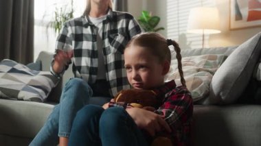 Kafkasyalı aile problemi evde bağırarak anne kadına kabadayılık taslıyor, tartışarak küfür ediyor, küçük üzgün kız çocuğu, kulakları açık, Teddy 'ye sarılıyor, aile içi şiddet uyguluyor.