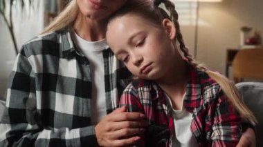Evde beyaz bir aile var. Sevecen bir anne. Kadın anne, teselli konsolu. Öpüşme.