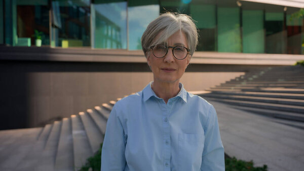 Outdoor portrait of Caucasian senior middle-aged businesswoman real estate agent adult female business person entrepreneur employer leader mature woman lady smile looking at camera in city downtown