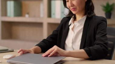 Asyalı iş kadını Çinli Koreli Japon kız iş kadını kadın iş kadını tasarımcı yönetici işveren etnik kadın kapalı mekanlarda dizüstü bilgisayar açmaya başlıyor.