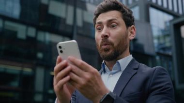 Beyaz adam kazananı mutlu erkek iş adamı iş adamı... online yatırımcı... kumar cep telefonu mesajını kazan... zafer kazan... açık havada akıllı telefon başarısını kutla...