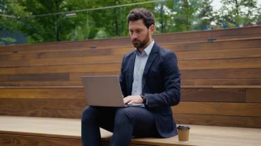 Beyaz adam iş adamı, milenyum girişimcisi, işadamı, işadamı, sokak mimarı, sokak işvereni, online dizüstü bilgisayarı kullanan, kameraya bakan, şehirdeki veri bağlantılarını inceleyen biri.