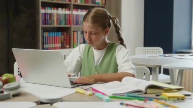 Beyaz kız liseli öğrenci masa başında eğitim sınavı yazıyor. Ev ödevi yazıyor. Uzaktan eğitim alıyor.