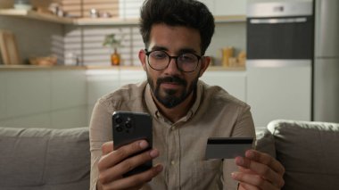 Mutlu Arap adam müşteri bankası kredi kartı sahibi bankacılık uygulamasında cep telefonu ödemesi olan ev mutfağı ödeme internet mağazasında ürün sipariş dağıtım hizmetleri kolay para transferi e-ticaret