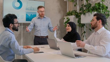 Şirket CEO 'su ekip lideri konferansta çeşitli iş arkadaşlarıyla yaptığı brifinglerde görüntüyü analiz ediyor iş adamları iş kadınları proje planını tartışıyor finansal strateji üzerine kafa yoruyor.