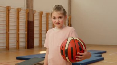 Beyazların küçük kızı spor salonu ilkokulu öğrencisi elinde basketbol topu olan çocuk antrenman şampiyonu beden eğitimi öğrencisi.
