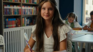 İlköğretim, Kafkasyalı ergen kız öğrenci kız öğrenci kız öğrenci kız çocuk kütüphane sınıfı gülümseyen öğrenci portresi öğrenen çocuklar ödev okumayı öğrenen kitap okuyan öğrenciler.