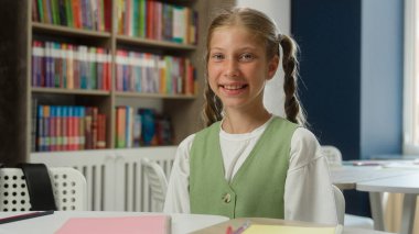 Portre kızı okul eğitimi dersi mutlu öğrenci öğrenci öğrenci kız liseli kız öğrenci akademisi öğrencileri sınıfta neşeli genç çocuk kameraya bakıp gülümsüyor ve çalışıyor.