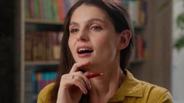 Yakın plan beyaz kadın pozitif yüz düşleri kuruyor düşünceli lise öğrencisi z öğrenci koleji kütüphanede gülümseyen, rüya gören barış yanlısı bir kadın.