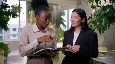 Afrikalı Asyalı kadın iş ortakları çeşitli etnik köken kızları iş kadınları çok ırklı Amerikalı iş arkadaşları ofis arkadaşları kameraya gülümseyen ticaret girişimleri danışmanı öğrencileri hakkında konuşuyorlar