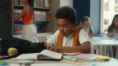 Afrikalı Amerikalı çocuk çocuk çocuk öğrenci öğrenci çocuk ilkokul öğrencisi ilkokul dersi yazı kitabı ile bitiyor masa başında öğrenim öğrenimi kütüphanede öğrenim kitapları öğreniyor.