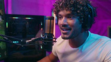 Mutlu, heyecanlı Arap erkek, bilgisayar bağımlısı, e-spor, video oyunu blogcusu, oyuncu zaferi, evet mikrofon flamalı gülümseme, internet evindeki vlogger erkek bilgisayar neon oyunu.