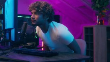 Latin Müslüman Arap erkek flamalı blogcu etkileyicisi kulaklıkları takıyor mikrofon bilgisayar radyo sunucusu oyuncu akışı sunucusu erkek oyuncu gelip canlı yayında canlı yayında konuşan oyuncu podcast ağı