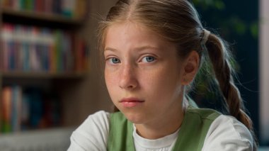 Uykunu kapat, üzgün, üzgün, beyaz kız, liseli kız öğrenci, yorgun, düşünceli öğrenci, kameraya bakıyor, gözlerini ovalıyor, uykusuzluk çekiyor, okul kütüphanesinde uykusuzluk çekiyor.
