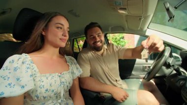 Aile sürprizi, beyaz erkek, gülümseyen erkek, ev anahtarlarını gösteren mutlu erkek, emlak satın alan, heyecanlı kadın, kız arkadaş, araba içinde kutlama yapıyor.