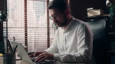 Kafkasyalı erkek müteahhit şirket işvereni. İşveren yönetici. Laptop teknolojisi yönetici broker 'ı kullanıyor.