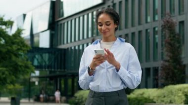 Afrika kökenli Amerikalı iş kadını kadın işkadını kadın işveren şehirde gülümseyen mutlu sohbetler yapan akıllı telefon uygulaması cep telefonuyla uzak mesafelere giden internet üzerinden ofise gidin.