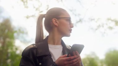 Kafkasyalı bir kadın cep telefonuyla etrafta dolanıyor kayıp kızla buluşuyor parktaki iş kadını turist gps yer belirleme uygulaması navigasyon teknolojisi internet şehir araştırması cep telefonu coğrafi konumunu gösteriyor