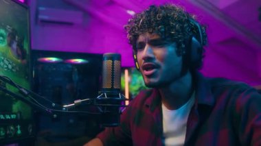 Heyecanlı Arap Latin Müslüman adam bilgisayar oyunu oynuyor erkek oyuncu flamalı film bağımlısı vlogger turnuvası siber spor oyunu sohbet mikrofon blogu blogu etkilenen ev neon çevrimiçi duygularını tartışıyor