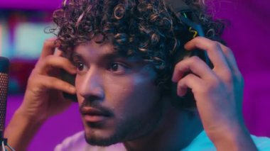 Arap Müslüman adam, kulaklık takıyor. Etkilenen erkek oyuncu rolüne hazırlanıyor. Blogcu, radyo, radyo, video oyunları gecesi mikrofon ve video oyunları oynuyor.