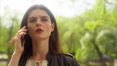 Sinirli, tatminsiz, Kafkasyalı bir kadın cep telefonuyla konuşuyor. Akıllı telefon, konuşma, yanlış anlaşılma, kavga, kadın iş kadını bağırma, açık hava tartışması, iş dünyası çığlık parkı.