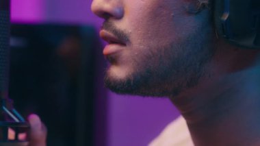 Arap Latin Hintli adam mikrofon mikrofon mikrofon kayıt podcast sesi yayınlayan oyuncu, oyuncu, bilgisayar etkileyicisi blog yazarı, Neon radyo sunucusunda konuşan adam için hazır olun.