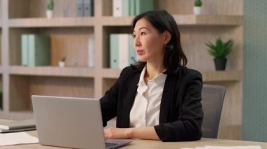 Ofisteki düşünceli Asyalı iş kadını Çinli Koreli iş kadını Japon etnik kız girişimci şirket lideri yönetici CEO 'su işveren sırıtan kadın portresi