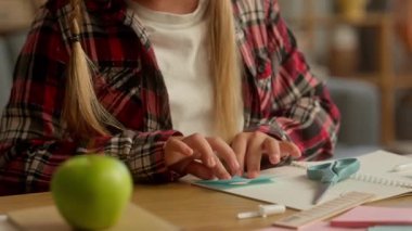 Yaratıcı, beyaz, ilkokul öğrencisi, evde origami ödevi yapan kız öğrenci. Öğrenci kız, ebeveyn okulu ödevi için el yapımı bir hediye. Küçük kız, kağıt katlama hobisi.