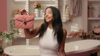 Latin kökenli bir kadın banyodaki mutlu İspanyol alışveriş mağazasından yeni moda çanta ve bot dağıtım mağazası indirimi satın alan kadın tüketici siparişi veriyor.