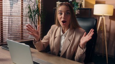 Şaşırtıcı bir şekilde Kafkasyalı iş kadını kadın ofis çalışanı serbest çalışan iş kadını dizüstü bilgisayarda çalışan iş kadını kameraya bakıp haykırarak zafer kazandı.