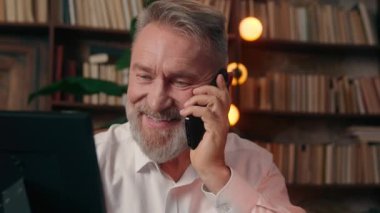 Mutlu Kafkasyalı yaşlı adam fotoğraf çerçevesi tutuyor. Emekliler cep telefonundan konuşuyor. Yetişkin büyükbaba içeride gülümseyen iş adamı arıyor.