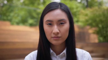 Ciddi iş kadını Asyalı Koreli Çinli kadın Japon kız öğrenci şehri kameranın iş portresine bakıyor kendine güvenen işveren bayan girişimci üzgün işçi.