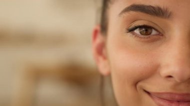 Yarı yüz portresi Hintli etnik İspanyol kadın Arap kadın evde gülümseyen kameraya bakarak tensel güzellik estetik cerrahi kozmetik prosedürleri sağlık tıbbı gülümsemesi