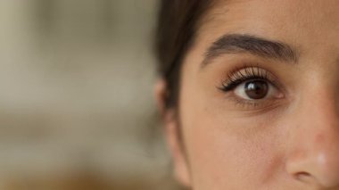 Aşırı kapalı yüz sakin koyu gözlü Hintli Arap kadın kırpılmış görüntüsü sağlıklı kız bakışı sağlık kliniği lazer düzeltme göz doktorluğu kamera görüş açısına bakıyor iç mekan makyaj