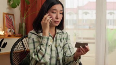 Asyalı, Asyalı, Çinli, elinde kredi kartı tutan, konuşan, cep telefonlu, akıllı, iş kadını, ödemeli, ev arama desteği, banka hizmetlerini engelleyen bir kadın.